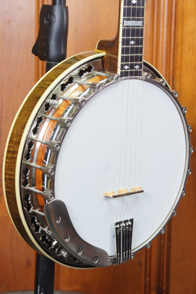 1984 Stelling Whitestar top tension 5-string banjo with star-shaped flange cutouts, flamed maple resonator, wooden contoured armrest and tension bolts around the top of the hoop