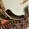 Side profile view of Stelling Red Fox banjo showing curved armrest and rim construction