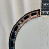 Side profile of Recording King RKR-80 banjo showing mahogany resonator rim and nickel-plated tension hoop brackets