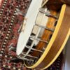 Side profile of a 1960s Fender Artist banjo showing one-piece flange and walnut resonator with cream binding