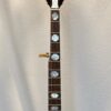 Front view of peghead on 2005 Gibson RB-18 Top Tension showing pearl script Gibson logo and Art Deco torch inlay