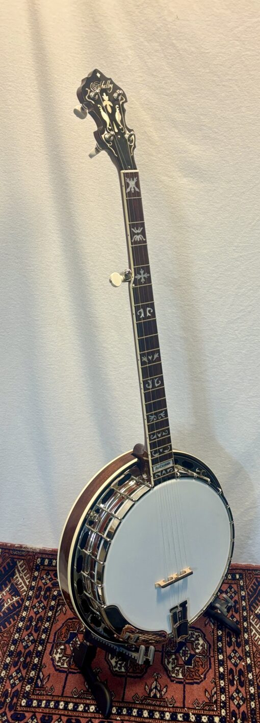 Side view of Shelby Blackhawk banjo showing mahogany resonator with cream binding