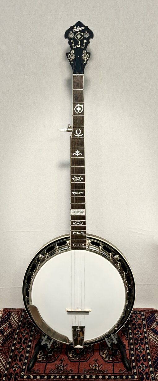 2005 Gibson RB-3 5-string banjo with wreath inlay pattern displayed on stand, showing full instrument with white head, rosewood fretboard, nickel hardware, and ornate pearl inlays