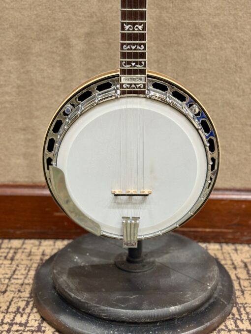 Close-up of Gibson TB-4 Mastertone pot assembly showing one-piece flange, chrome armrest, Mastertone inlay, and walnut resonator binding.