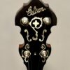 Close-up of Gibson banjo headstock featuring Gibson script logo, four-leaf clover center inlay surrounded by ornate pearl scrollwork, and nickel planetary tuners
