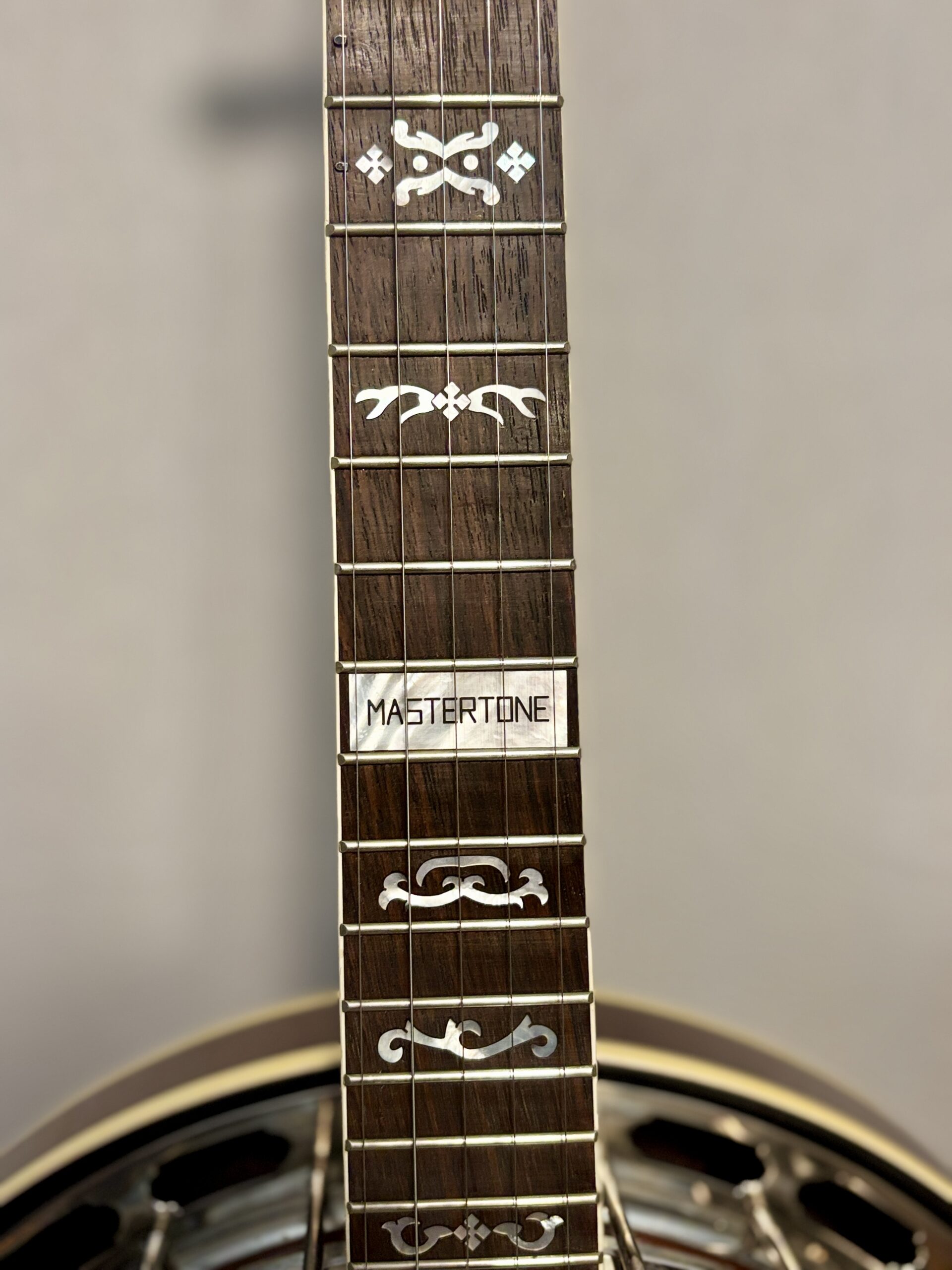 Lower frets of Gibson RB-3 showing Mastertone block inlay at 22nd fret, decorative inlays, and portion of nickel resonator flange