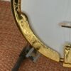 Macro detail of the Huber Truetone Custom 625-13 hand-engraved gold-plated armrest and the curly maple resonator binding Macro of the hand-engraved gold armrest and curly maple resonator binding on the Huber Truetone Custom 625-13.
