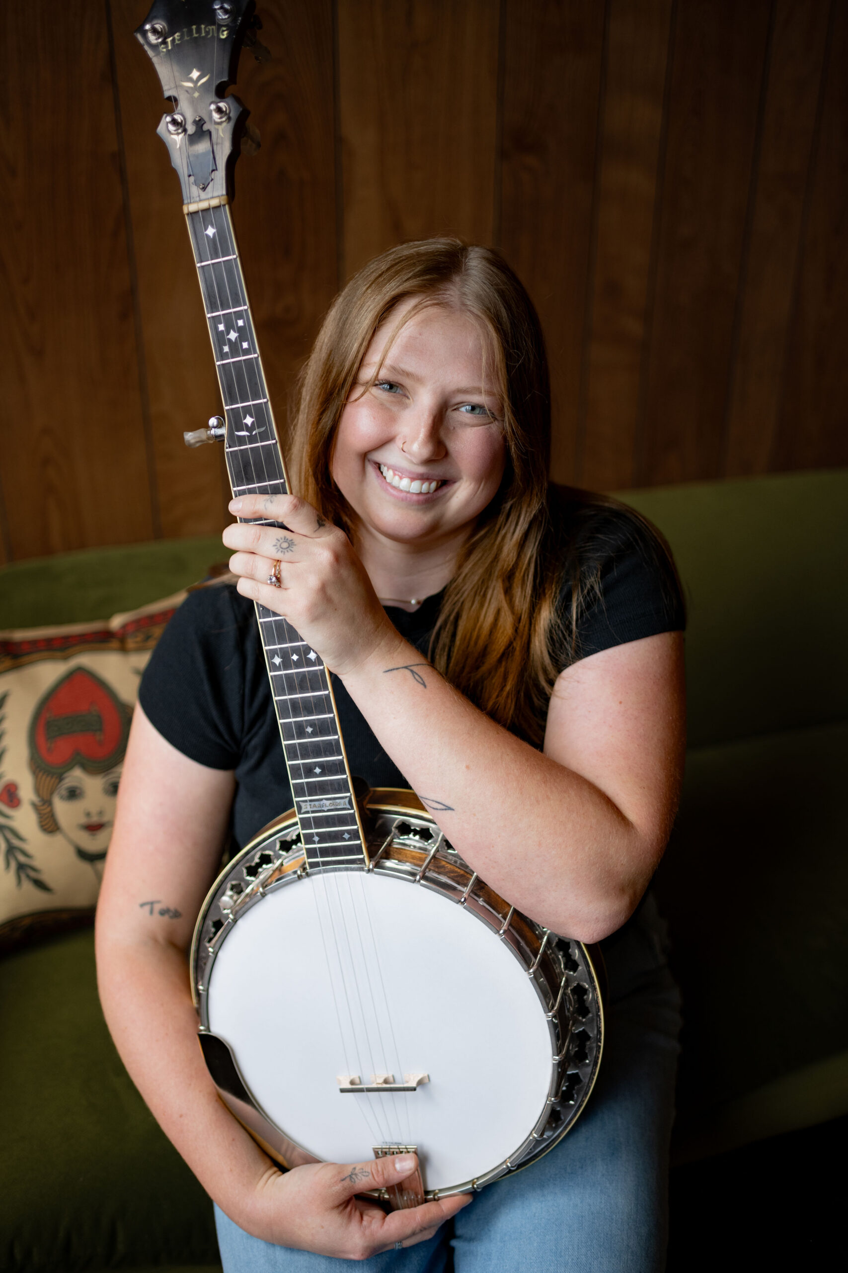 Banjo tech Tara at Banjo Warehouse in Yellow Springs, Ohio, holding a Stelling Starflower banjo